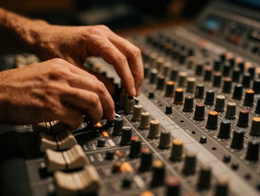 Extreme close-up of hands on a professional mixing console in a dark studio, warm amber highlights, shallow depth of field.