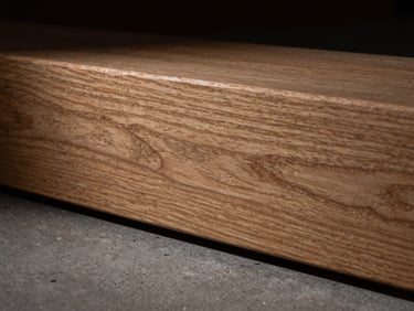 Macro detail shot of a perfectly joined oak beam with visible grain, low-key side-lighting, deep shadows, 35mm lens.