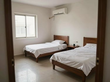 Girls PG room in Indirapuram — two single beds with white linens, AC unit on the wall, daylight from window, clean tiled floor, wide shot from doorway, no people, honest documentary lighting