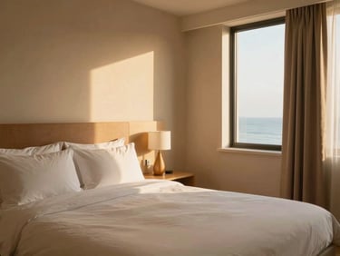 Clean and cozy deluxe hotel room interior with soft sand tones, warm morning light, 35mm lens