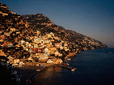 Cinematic shot of the Amalfi Coast at golden hour, colorful cliffside buildings, deep blue sea below