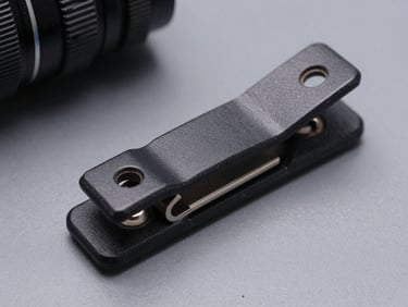 Close-up macro studio shot of a rare automotive OEM plastic clip and mounting bracket on a grey surface, sharp detail on surface texture and dimensional accuracy, cool studio lighting