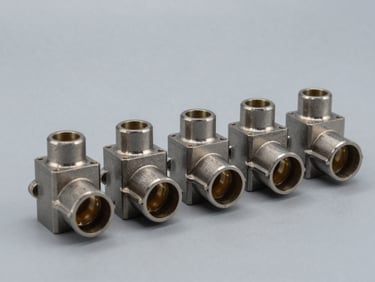 Three-quarter studio shot of a small batch of identical precision industrial connector housings arranged in a neat row on matte grey surface, consistent studio strobe light, cool neutral tone, no hands
