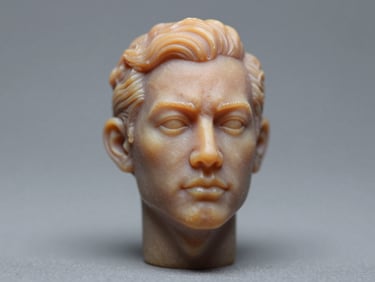 Macro studio shot of a detailed resin human figurine engineered from a photograph, showing fine facial surface texture and dimensional accuracy, placed on a cool-grey surface under daylight-balanced strobes, crisp focus on the face