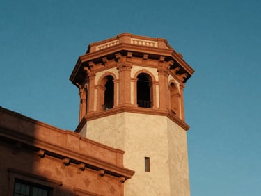 High-contrast architectural photograph of a historic theater tower against a clear blue sky, warm terracotta details visible.
