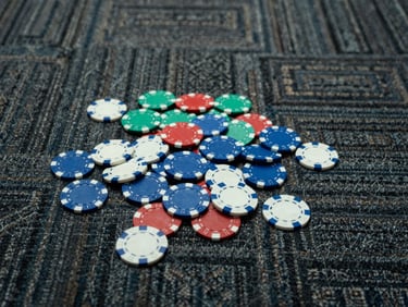 Clinical overhead shot of discarded casino chips on a patterned carpet, harsh artificial lighting, cold tones.