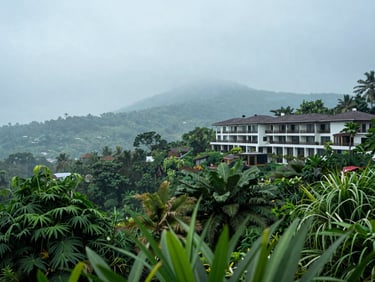 Misty Lonavala hillside view from a resort balcony, lush green foliage in foreground, soft overcast daylight