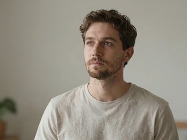 Portrait apaisant d'un homme hypnothérapeute, regard calme, fond neutre, lumière douce