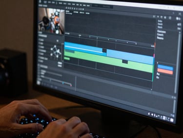Editing timeline on a dark monitor screen, color grading curves visible, hands on keyboard partially lit by screen glow, shallow depth of field
