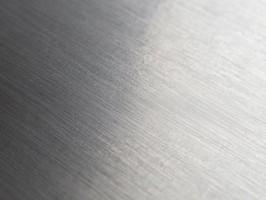 Macro close-up of stainless steel flat sheet surface, brushed 2B finish detail, cool studio lighting, no color cast, true metal tone, sharp grain texture visible