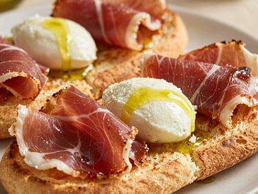 Close-up of toasted paninis filled with prosciutto, fresh mozzarella, and a drizzle of olive oil, warm afternoon light.
