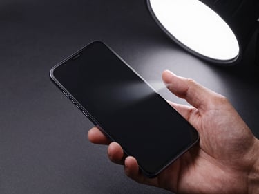 Overhead close-up of developer hand holding Android device mid-swipe gesture, studio strobe light, dark matte surface beneath, motion blur on fingertip