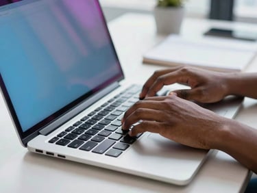 Close-up of hands typing on a sleek laptop keyboard, subtle blue glow from screen, modern office desk, natural daylight