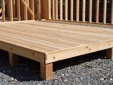Angled shot of a newly finished timber deck framing, heavy-duty joists, crisp mountain light casting shadows on the gravel below.