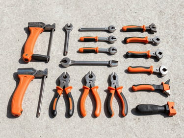 Straight-on clean shot of organized tools laid out systematically on a concrete floor, bright daylight, high-contrast slate tones, 35mm.