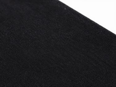 Macro close-up of high-fidelity DTF print on black cotton fabric, showing ink perfectly bonded to the textile fibers, bright studio product photography, sharp focus, 50mm