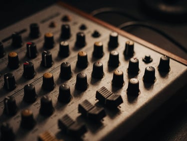 Detail shot of vintage analog synthesizer knobs and patch cables, moody studio light, deep shadows, tactile textures