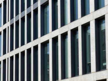 Architectural lines of a modern office building interior, focusing on structured pathways, crisp natural daylight, deep navy and emerald tones, sharp focus, 35mm