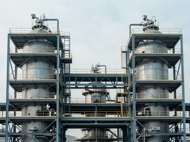Symmetrical architectural photograph of a modern mineral processing facility with steel scaffolding, desaturated steel blue tones, crisp daylight.