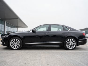 Side profile of a polished black executive sedan parked outside a modern terminal, sharp focus, clean metallic tones.
