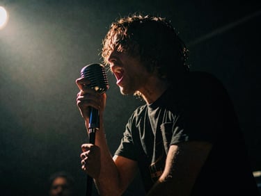 Vocalist screaming into a vintage microphone, dramatic backlighting, deep shadows, gritty concert photography.