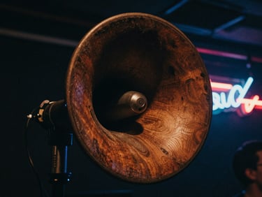 Close-up of a massive hand-built wooden speaker horn, deep shadows, electric neon flares, gritty concert venue aesthetic