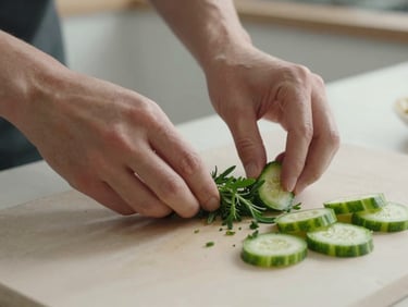 Close-up of hands gently arranging fresh herbs and sliced vegetables on a pale stone surface, soft diffused daylight from the side, calm minimal kitchen setting, no clutter
