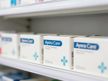 Close-up of clean Ayora Care packaging on a bright pharmacy shelf, soft natural lighting, crisp medical white and blue tones, 50mm lens.