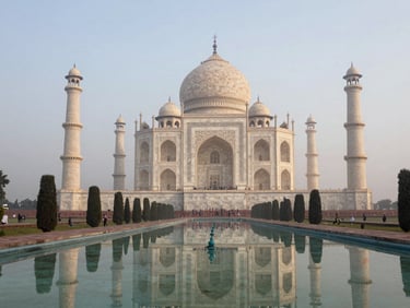 Wide establishing shot of the Taj Mahal at early morning, mist rising from the Yamuna behind it, foreground reflection pool drawing the eye, overcast diffused light, no crowds visible