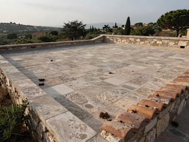 Wide shot of a clean Corsican stone rooftop after treatment, early morning overcast light, terracotta tiles free of biological growth, surrounding maquis vegetation visible at the edges, documentary natural tones