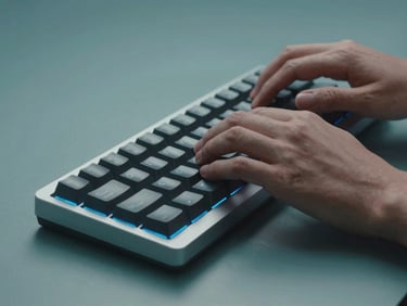 Sleek tech photography, close-up of hands typing on a minimalist mechanical keyboard, cool studio lighting with teal accents, crisp details, 50mm