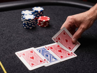 Mid-shot overhead of casino table with cards being dealt mid-motion, bright studio lighting, chips stacked beside the hand, sharp focus on card edges, high-contrast dark felt surface