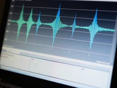 Macro shot of a spectrum analyzer screen displaying complex frequency data, with subtle blue and green lines against a dark background.