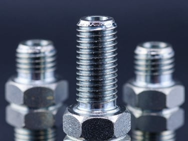 Macro shot of heavy-duty steel hydraulic fitting threads, sharp metallic reflections, deep navy background, cool steel tones, 35mm photography