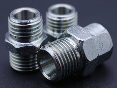 Macro shot of BSP and NPT threaded steel adapters, high-contrast metallic lighting, cool steel tones, 35mm