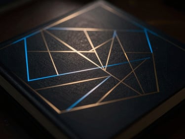 Close-up of a sleek, dark book cover with glowing geometric patterns in electric blue and gold, reflecting subtle ambient light, dark cinematic photography, dramatic chiaroscuro lighting, 35mm