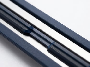 Macro studio shot of a premium aerodynamic wiper blade, highlighting the precision-molded rubber edge and sleek metallic frame, cool high-contrast lighting, deep navy and silver tones