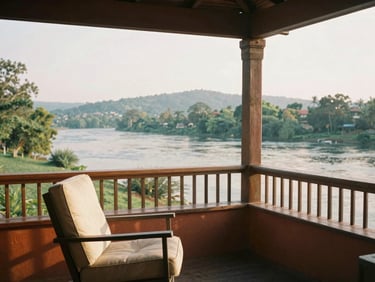 Riverside veranda with a comfortable chair, open views of the river and hills, warm morning light, warm editorial photography, 35mm film.