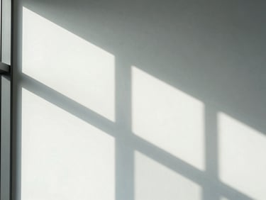 Abstract geometric shadows falling across a clean white wall in a modern office, sharp contrast