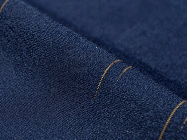 Macro close-up of deep blue polyester fabric weave, showing high-tenacity synthetic fibers with a subtle technical sheen, clean studio lighting