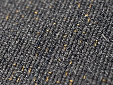 Macro close-up of blended grey textile showing interwoven cotton and polyester threads, balanced texture, neutral studio lighting