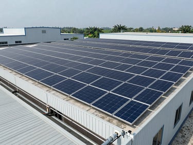 Wide environmental shot of a commercial rooftop solar installation on a large flat industrial or warehouse building in Bihar, overcast daylight, full high-capacity panel array visible, no people, close-up of wiring conduit and galvanized structure in the lower foreground