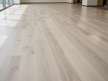Wide environmental shot of a commercial office floor in light ash, freshly installed and lacquered, north-facing daylight, no people, no furniture, grain running parallel to the frame