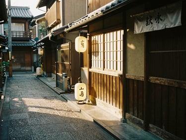 Golden hour sunlight hitting a narrow wooden alleyway in Kyoto, a small glowing lantern outside a ramen stall, 35mm film grain.