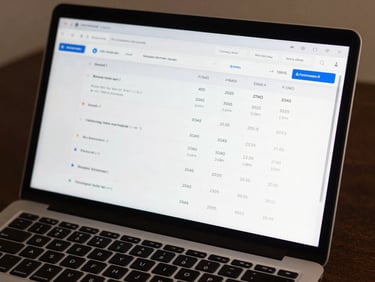 Close-up of a laptop screen showing a Meta Ads Manager dashboard with campaign performance metrics, ROAS and conversion columns clearly visible, even studio lighting, dark desk surface, sharp screen readability