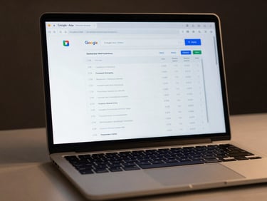 Close-up of a laptop screen displaying a Google Ads campaign dashboard with performance metrics, CTR and conversion columns clearly visible, even studio lighting, minimal desk surface, dark background