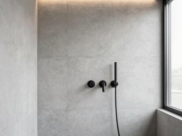 Minimalist bathroom interior with light grey concrete walls and matte black fixtures, soft side lighting.