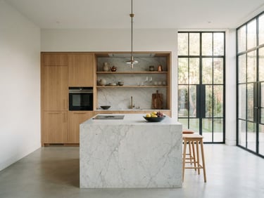 Straight-on architectural photography of a modern minimalist kitchen, white marble island, warm oak cabinetry, soft morning light streaming through large steel-framed windows