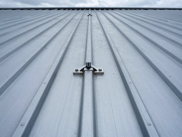 Close-up of double-lock zip seams on a massive industrial metal roof, metallic blue tones, crisp overcast daylight, technical engineering photography, 35mm