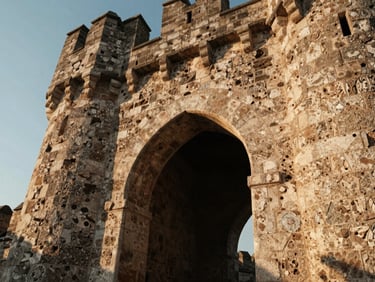 Low-angle shot of a stone archway inside a medieval tower, warm sunlight streaming through, highlighting the ancient masonry.